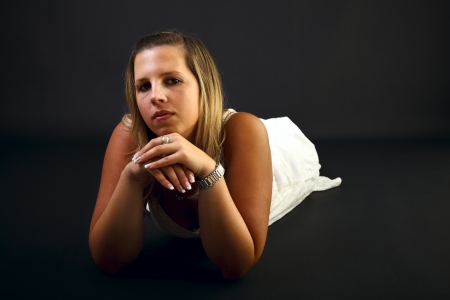 Young blond woman on black background, studio shot. の写真素材