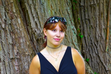 Portrait of a young woman in background willow tree trunks, outdoor in the park in small city Saarlouis, Saarland / Germanyの写真素材