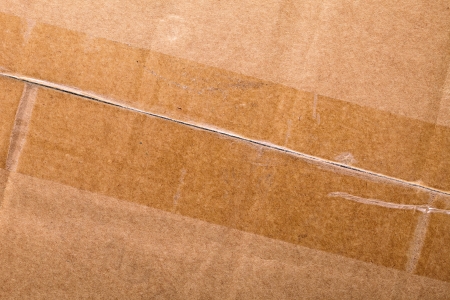 Close up of a cardboard with adhesive tape as backgroundの写真素材
