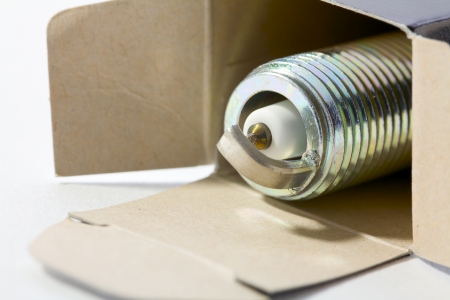 Close up of a spark plug in a cardboard box on white backgroundの写真素材
