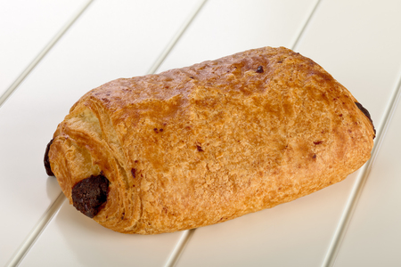 Sweet bun with chocolate on white wooden background.の写真素材