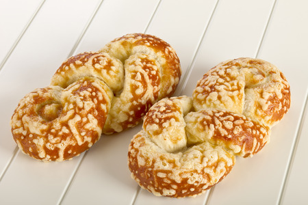 Bun with cheese gratin on white wooden background.の写真素材