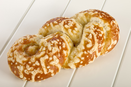 Bun with cheese gratin on white wooden background.の写真素材