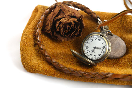 A watch and a dry rose on the leather bag. 6:13 am. Isolated background.の写真素材