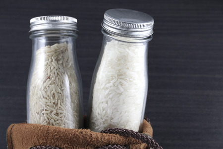 rice in the bottle in the leather bag on the wooden background.