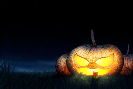 Halloween pumpkins are symbols of halloween night. Located in the middle of the field. Behind is the night sky.の写真素材