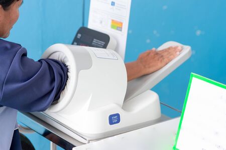 Patients are now measuring their blood pressure using a modern meter in the hospital.の写真素材
