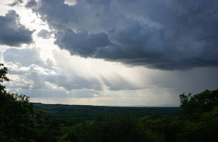 Sunlight shining through black cloudsの写真素材