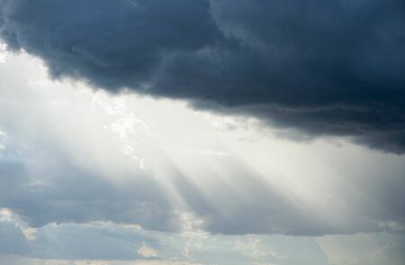 Sunlight shining through black cloudsの写真素材