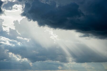 Sunlight shining through black cloudsの写真素材