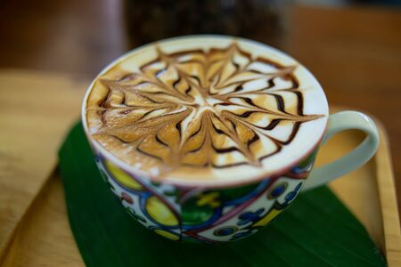 Hot latte coffee in a cup with a beautiful patternの写真素材