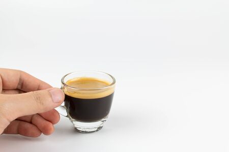 Cup of espresso coffee with hand on white backgroundの写真素材
