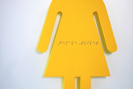 Font for the blind on yellow woman toilet signの写真素材
