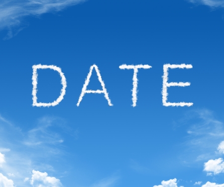 Date spelled in with clouds in the blue skyの写真素材