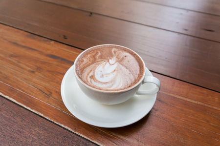 A cup of hot chocolate malt on wood tableの写真素材