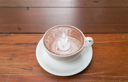 A cup of hot chocolate malt on wood tableの写真素材