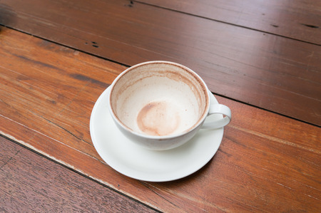A empty cup of hot chocolate malt on wood tableの写真素材
