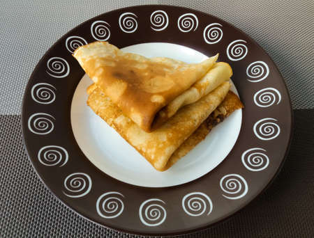 Appetizing pancakes on a plate. Homemade thin crepes for breakfast or dessert