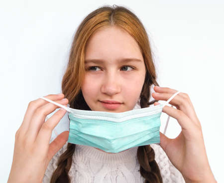 Girl puts a medical mask on her face.の写真素材