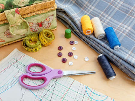 Sewing thread spools, measuring tape, textile, buttons and scissors. Sewing supplies, and...