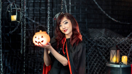 Portrait Teenage beautiful woman wearing witch costume holding pumkin in halloween theme.Emotion happyの写真素材