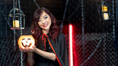 Portrait beautiful woman wearing witch costume holding pumkin in halloween theme.