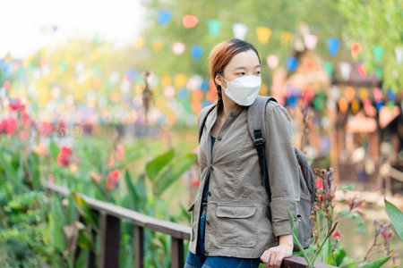 Beautiful traveler girl with mask and backpack  joyful on her journeyの写真素材