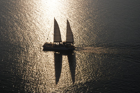 Yacht sailing against sunsetの写真素材
