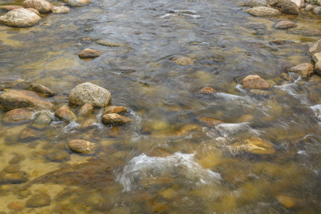 River and forrest rocks with visible movement and blur of the water. Landscape view