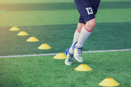 Kid soccer Jogging between marker cones for soccer training of academy.の写真素材