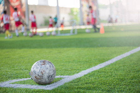 Football on corner for corner kick with blurry kid players.の写真素材