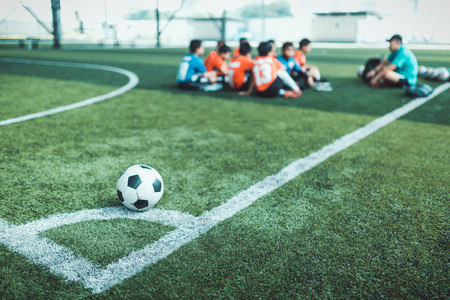 Football on corner for corner kick with blurry kid players.のeditorial素材