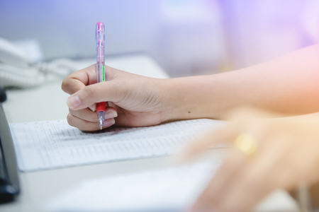 Lecture or writing on computer paper for checklist or audit information.の写真素材