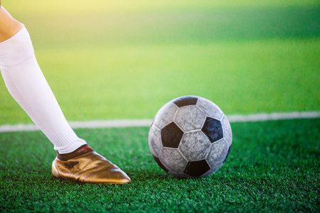 The soccer player shoot ball on artificial turf.の写真素材