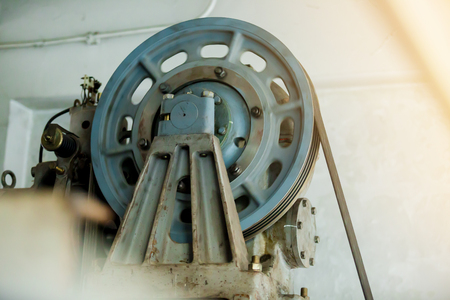Motor driven with sling cable and wheel in control room of passenger lift system.
