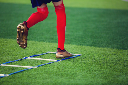 Soccer player Jogging and jump between marker for football training. Ladder Drills Exercises for Football Soccer team. Young player exercises on ladder drills.の写真素材
