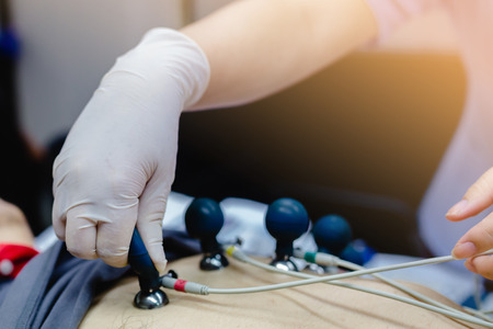 Electrocardiogram for heart and pulse measurement in hospital. Annual health check. Nurse measuring patients blood pressure electrocardiography. ECGの写真素材