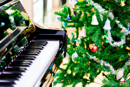 Piano and shine to Christmas tree for christmas holiday background. New Year holidays background.の写真素材
