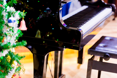 Piano and shine to Christmas tree for christmas holiday background. New Year holidays background.の写真素材