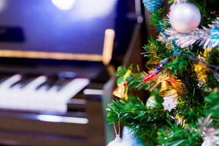 Piano and shine to Christmas tree for christmas holiday background. New Year holidays background.の写真素材