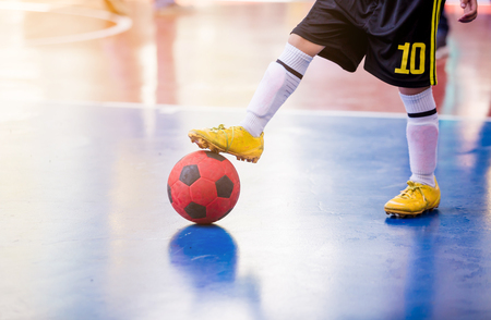 Kid futsal player  trap and control the ball for shoot to goal. Soccer players fighting each other by kicking the ball. Indoor soccer sports hall. Football futsal player, ballの写真素材