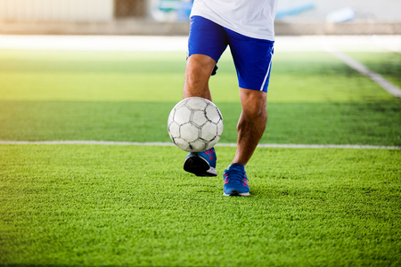 Soccer player speed run to shoot ball to goal on artificial turf. Soccer player training or football match.の写真素材