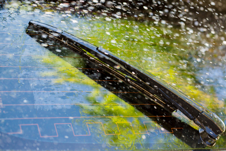 Car windshield with rain drops and frameless wiper blade closeupの写真素材
