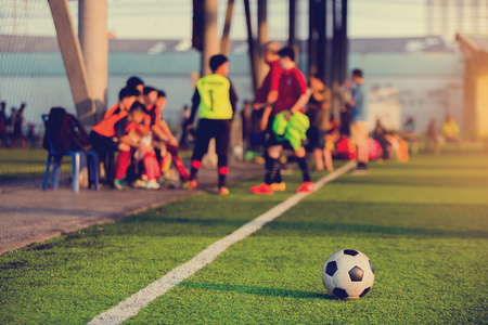 soccer ball at touchlines on artificial turf with blurry of soccer players and coach are coaching in game.の写真素材