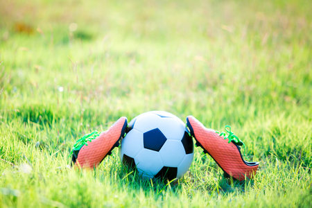 football and soccer shoes on the green grass for soccer player training and playing football.の写真素材