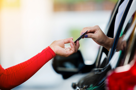 Selective focus to woman driver pay credit card with staff for fuel in gas station.の写真素材
