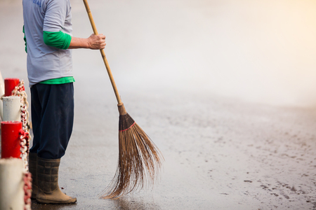 staff cleaning city street with broom tool and water sprayの写真素材