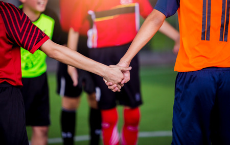 boy soccer players tap hands together for football training. Soccer players and goalkeeper training speed hand together.の写真素材