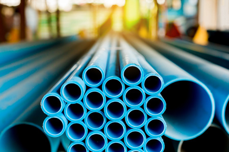 Close up to blue plastic pipe background, PVC pipes stacked in warehouse,  PVC water pipes used for...