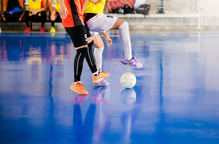 Futsal player  trap and control the ball for shoot to goal. Soccer players fighting each other by kicking the ball. Indoor soccer sports hall. Football futsal player, ball, futsal floor.の写真素材